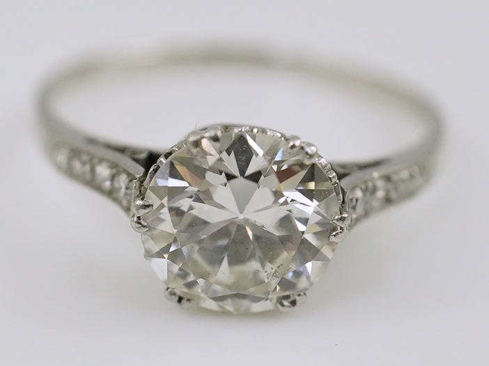 A platinum and single stone diamond set ring, with graduated eight stone diamond chip set shoulders, with a Mappin & Webb probate valuation dated 01/06/2024